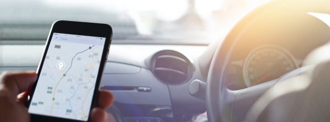 Hand using smartphone GPS navigation inside car